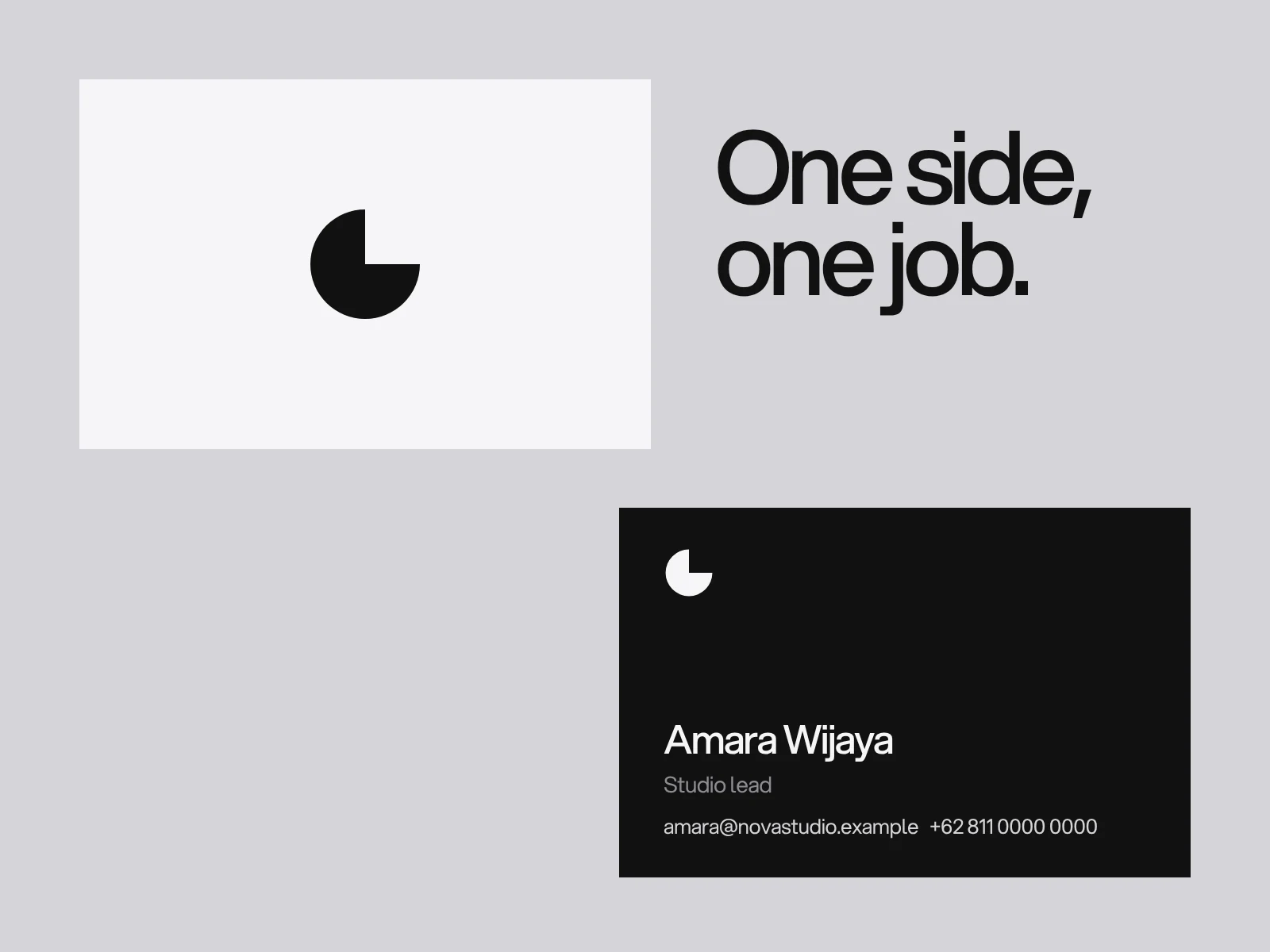 A white business card with a round mark and a black business card with a name and contact details, placed diagonally on grey